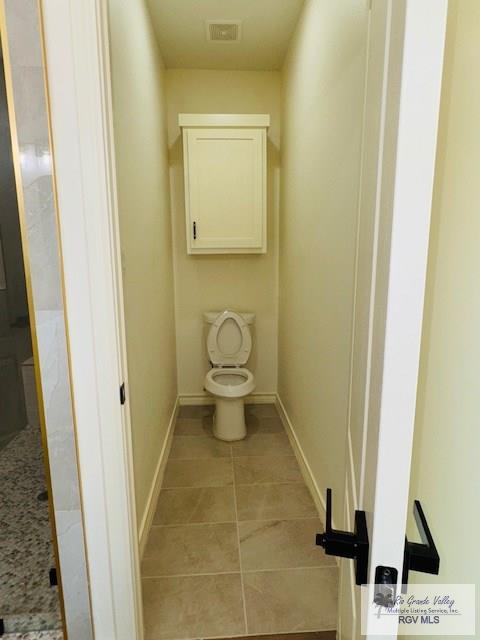 16602 Napper Ln, Primera, TX 78552 - bathroom featuring toilet, baseboards, and tile patterned flooring