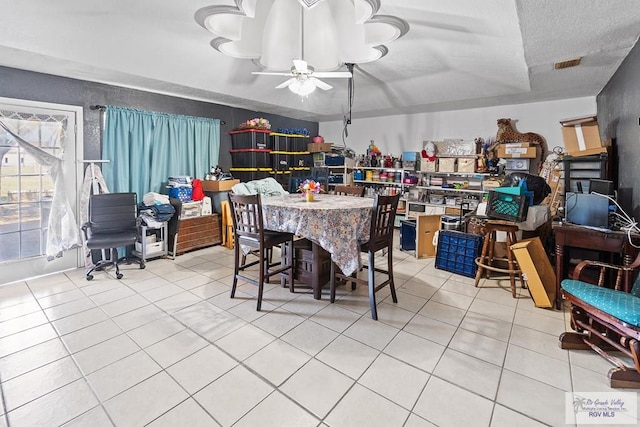 tiled dining room featuring ceiling fan and a textured ceiling