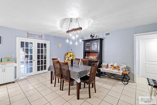 dining space with light tile patterned floors and french doors