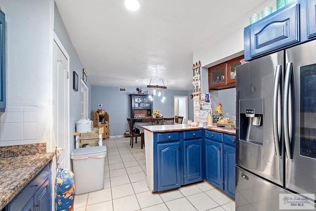 kitchen with light tile patterned flooring, kitchen peninsula, stainless steel refrigerator with ice dispenser, and blue cabinets