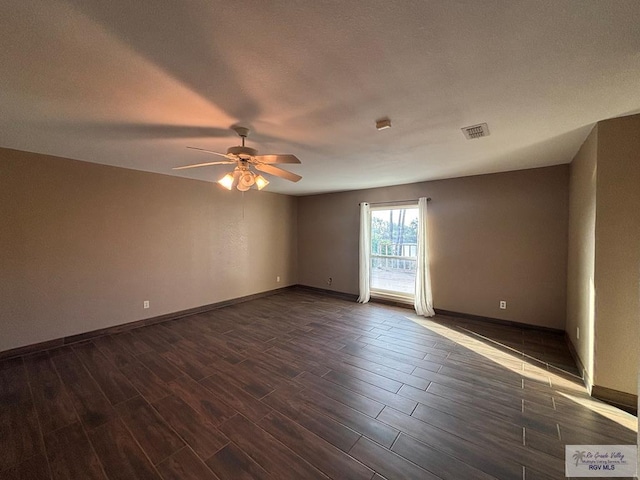 1060 Timothy St, San Benito, TX 78586 - spare room with visible vents, a ceiling fan, a textured ceiling, baseboards, and dark wood-style flooring