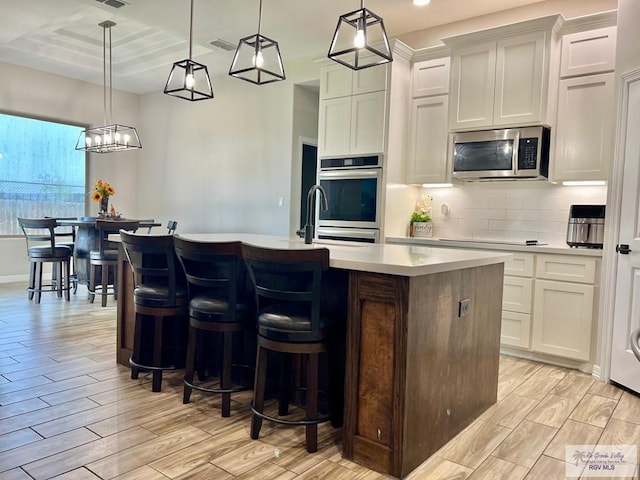 3706 Bea Ave, Harlingen, TX 78552 - kitchen featuring appliances with stainless steel finishes, a sink, light countertops, backsplash, and light wood-style floors
