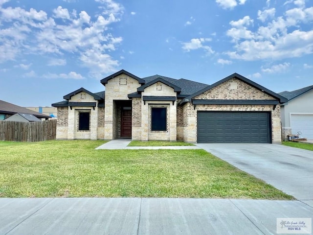 3706 Bea Ave, Harlingen, TX 78552 - view of front facade featuring a garage, driveway, stone siding, and brick siding