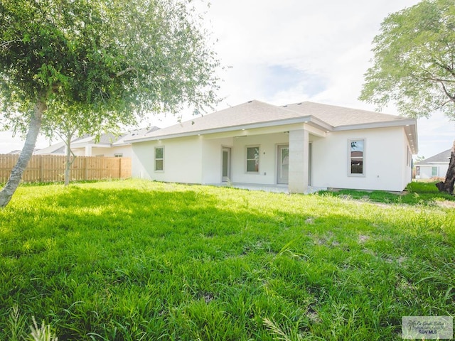 rear view of property featuring a lawn