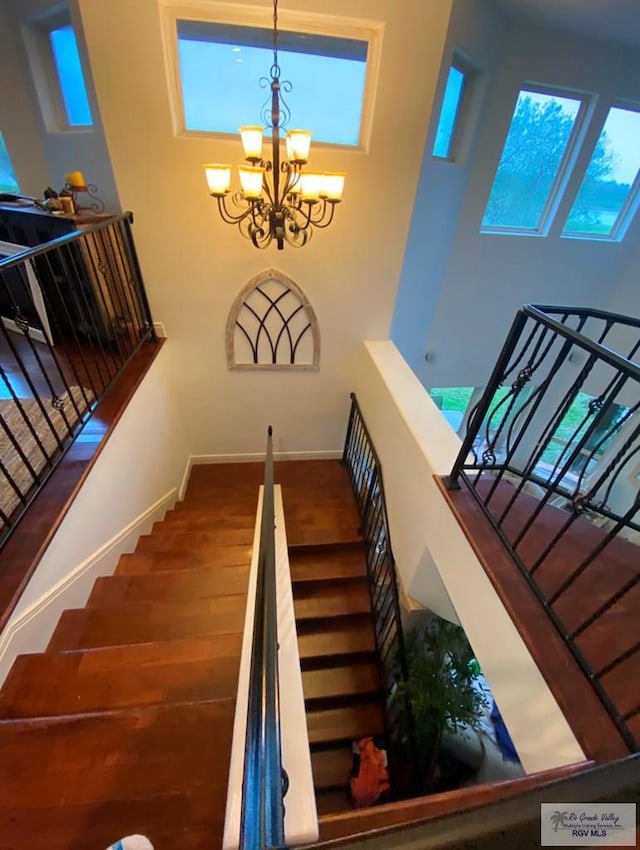 staircase with a high ceiling and a chandelier