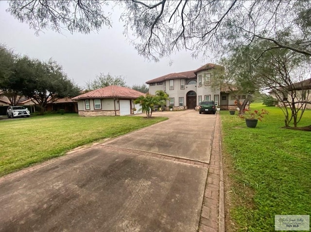 mediterranean / spanish-style house with a front yard and a garage