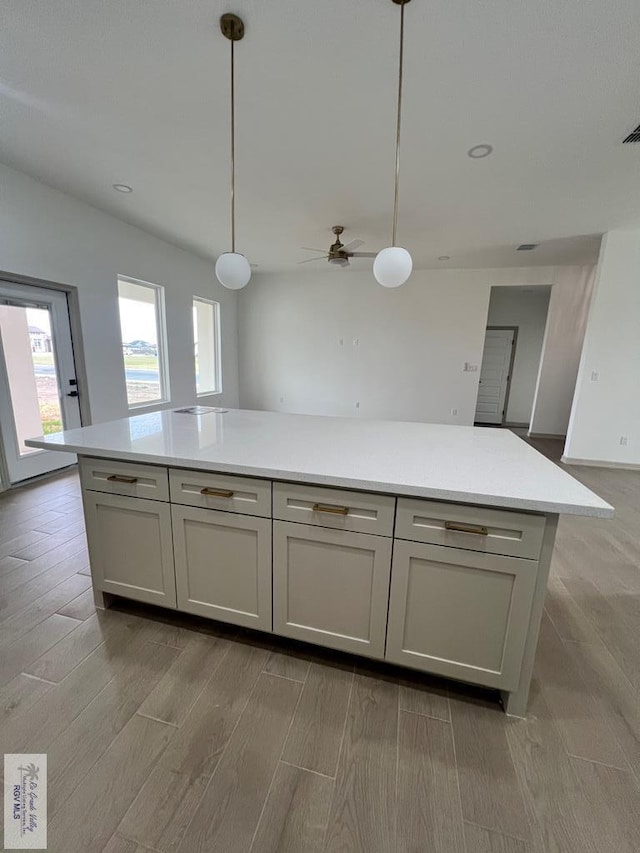 kitchen featuring pendant lighting, light wood-type flooring, and ceiling fan