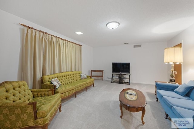 living area with visible vents, carpet floors, and a textured ceiling