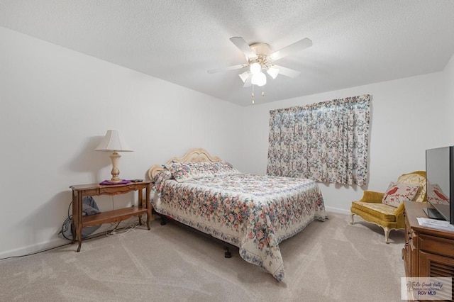 bedroom featuring carpet flooring, a textured ceiling, and a ceiling fan