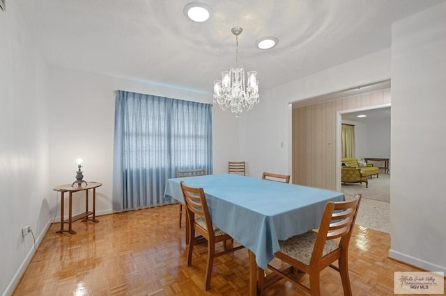 dining room featuring baseboards and a chandelier