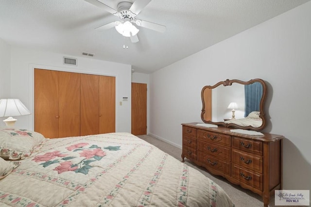 carpeted bedroom featuring baseboards, visible vents, a closet, and ceiling fan