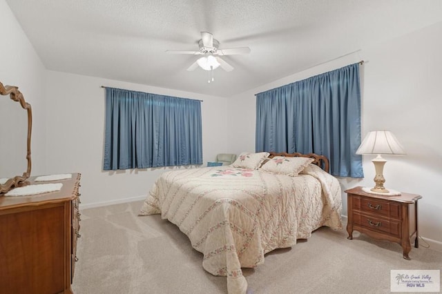 carpeted bedroom with baseboards, a textured ceiling, and a ceiling fan