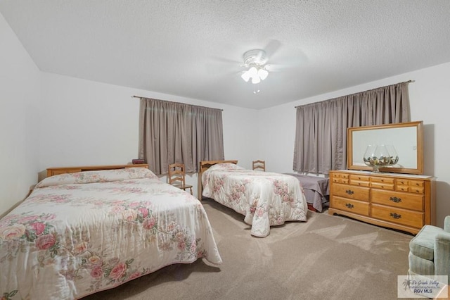 carpeted bedroom featuring ceiling fan and a textured ceiling