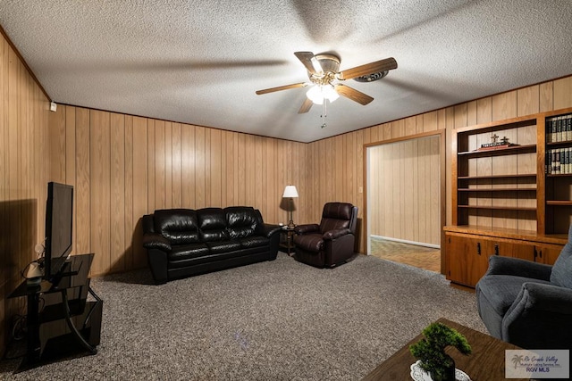 7969 Fm 2099, Lyford, TX 78580 - living area with wood walls, ceiling fan, carpet floors, and a textured ceiling