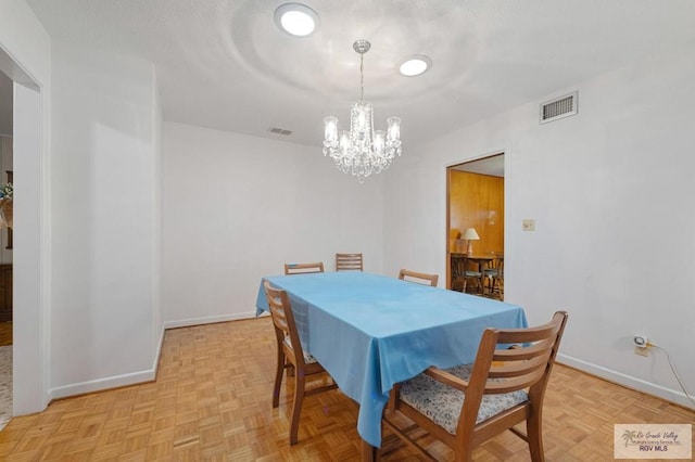 dining room featuring a chandelier, visible vents, a textured ceiling, and baseboards