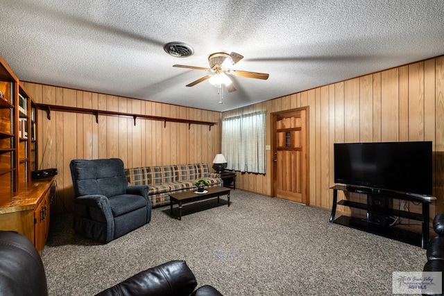 7969 Fm 2099, Lyford, TX 78580 - carpeted living area featuring ceiling fan, wood walls, and a textured ceiling