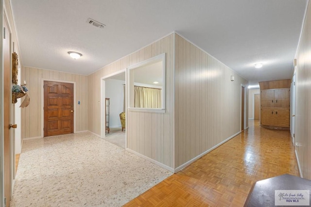 corridor with visible vents, baseboards, and a textured ceiling