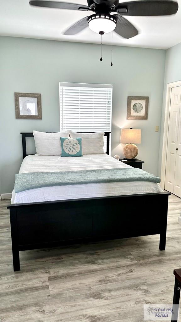 bedroom with ceiling fan and light wood-type flooring