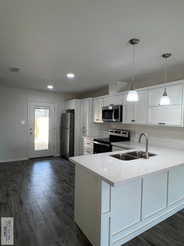 kitchen featuring white cabinets, kitchen peninsula, sink, and appliances with stainless steel finishes