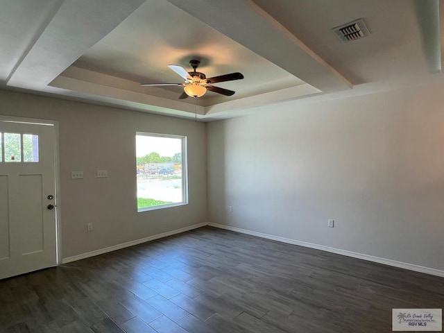 entrance foyer featuring a tray ceiling, ceiling fan, and dark wood-type flooring