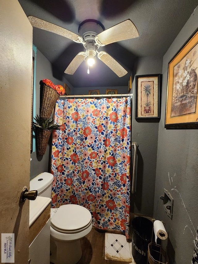 bathroom featuring ceiling fan, curtained shower, toilet, and a textured ceiling