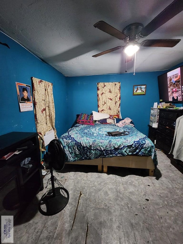 bedroom with hardwood / wood-style floors, a textured ceiling, and ceiling fan