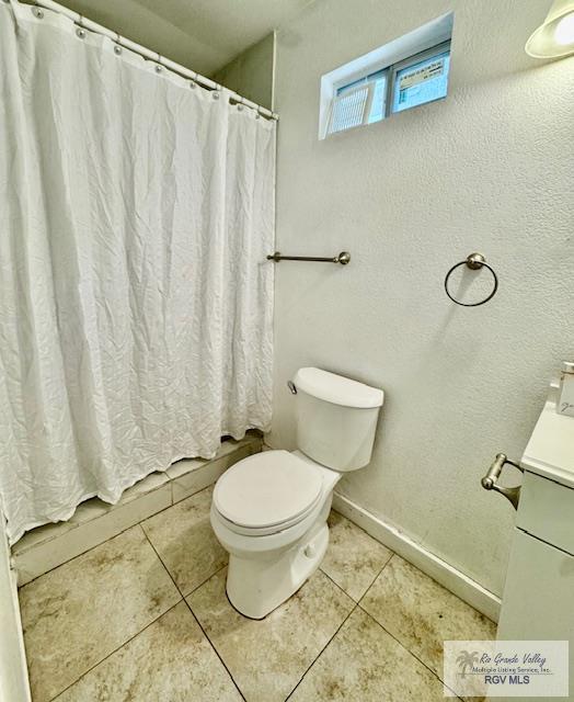 2413 Eastern Blvd, Brownsville, TX 78520 - bathroom with toilet, vanity, tile patterned floors, and baseboards