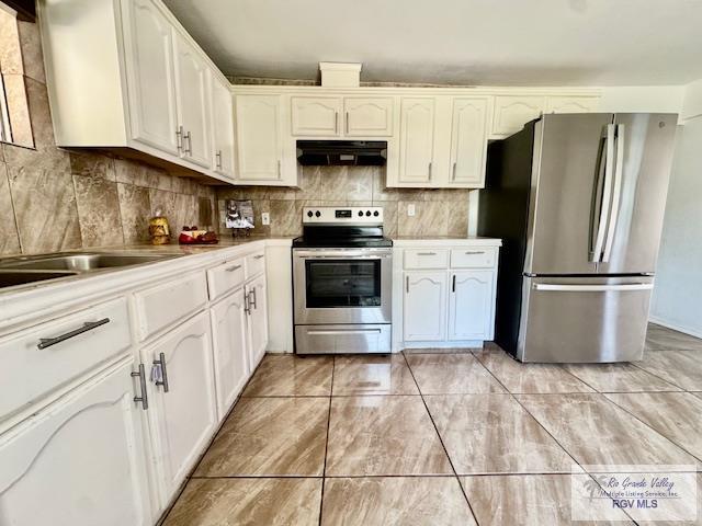 2413 Eastern Blvd, Brownsville, TX 78520 - kitchen featuring stainless steel appliances, under cabinet range hood, tasteful backsplash, white cabinets, and light countertops