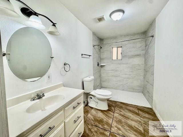 2413 Eastern Blvd, Brownsville, TX 78520 - bathroom with vanity, toilet, and tiled shower