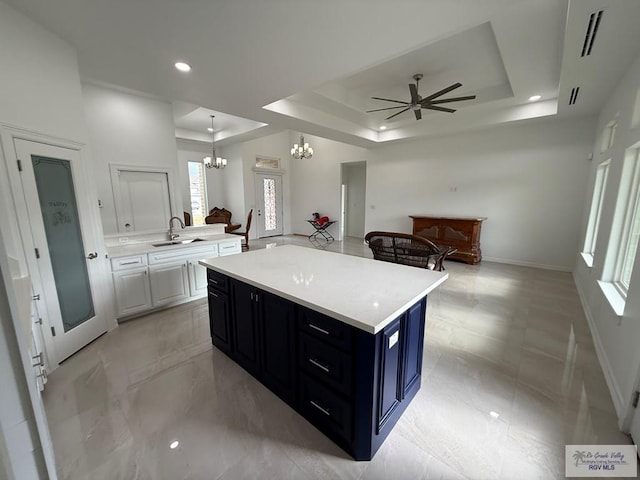 139 Heron Dr, Los Fresnos, TX 78566 - kitchen featuring a tray ceiling, a chandelier, light countertops, ceiling fan, and recessed lighting