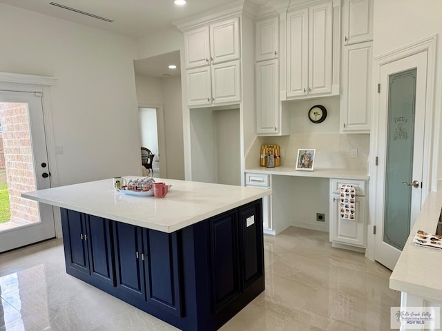 139 Heron Dr, Los Fresnos, TX 78566 - kitchen with white cabinetry, light countertops, blue cabinets, a center island, and recessed lighting