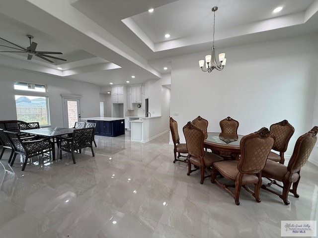 139 Heron Dr, Los Fresnos, TX 78566 - dining area with a tray ceiling, ceiling fan, a chandelier, light marble finish flooring, and recessed lighting
