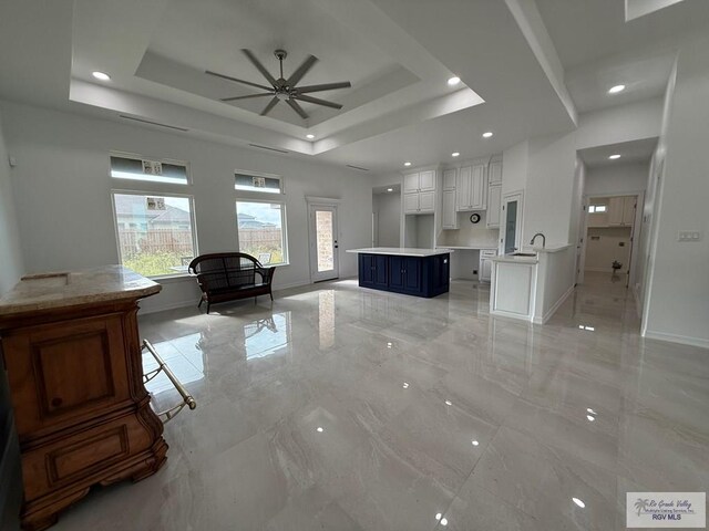 139 Heron Dr, Los Fresnos, TX 78566 - living room featuring a ceiling fan, light marble finish floors, a tray ceiling, and recessed lighting