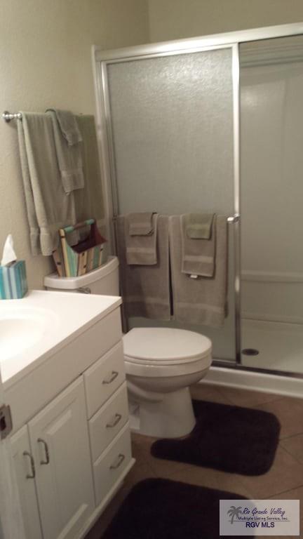 bathroom featuring vanity, toilet, and a shower with shower door