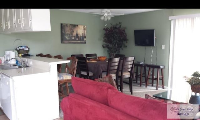 living room featuring ceiling fan and sink