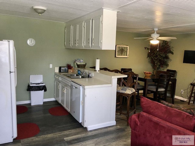 kitchen featuring sink, white cabinets, dark wood-type flooring, and white appliances