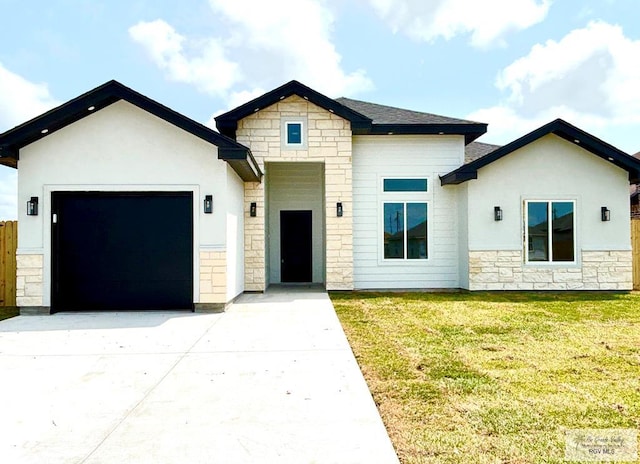view of front of property featuring driveway, stone siding, a front yard, fence, and a garage