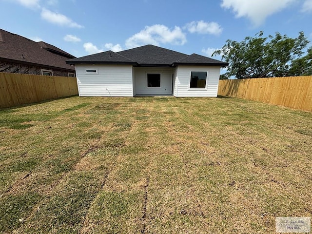 back of property featuring a fenced backyard and a yard