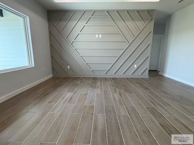 empty room featuring wood finished floors and baseboards