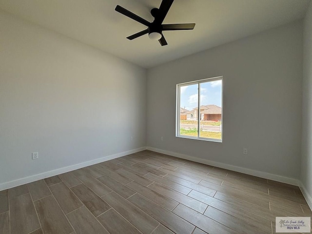 unfurnished room featuring wood finish floors, a ceiling fan, and baseboards