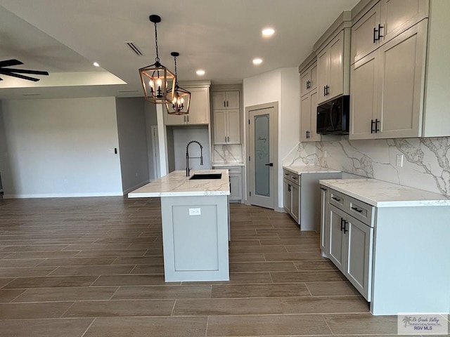 kitchen featuring wood finish floors, recessed lighting, black microwave, and visible vents