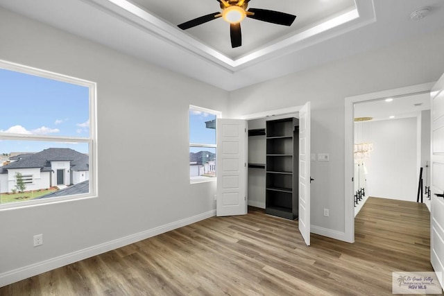 1013 Butler St, Edinburg, TX 78541 - unfurnished bedroom featuring a chandelier, wood finished floors, baseboards, and a raised ceiling