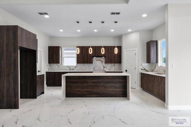 1013 Butler St, Edinburg, TX 78541 - kitchen with backsplash, light marble finish flooring, modern cabinets, dark brown cabinetry, and recessed lighting