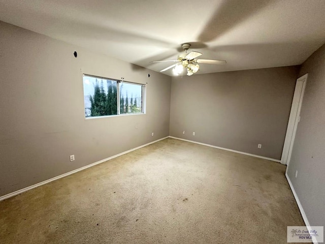 carpeted empty room featuring a ceiling fan and baseboards