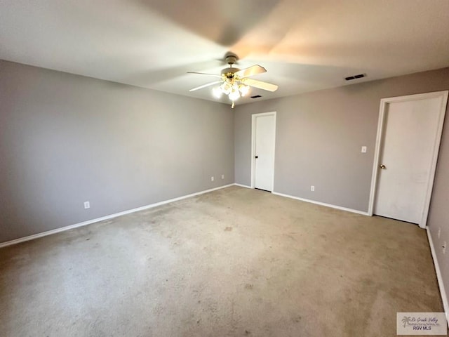 spare room featuring ceiling fan, visible vents, and baseboards