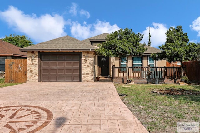 single story home featuring a porch, a garage, a shingled roof, driveway, and fence