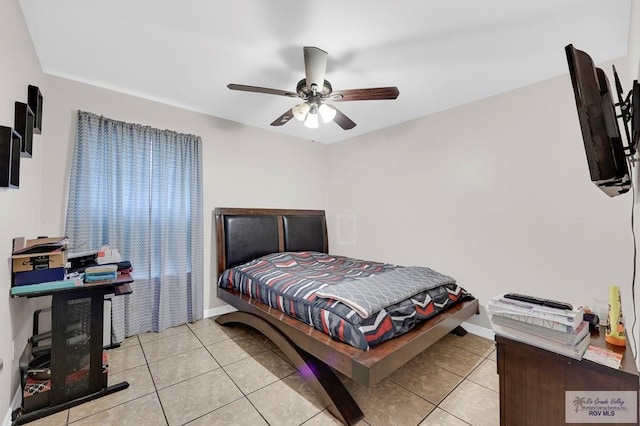 bedroom with light tile patterned floors, a ceiling fan, and baseboards