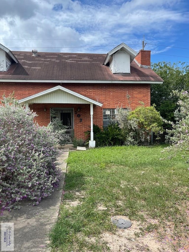 103 Alan A Dale St, Brownsville, TX 78521 - view of front of property with brick siding, a chimney, and a front lawn