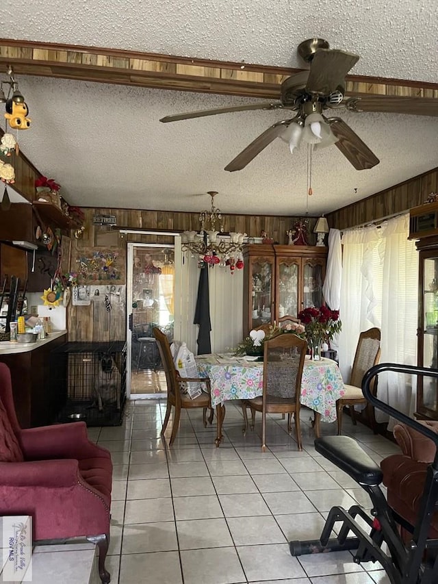 103 Alan A Dale St, Brownsville, TX 78521 - living room featuring a textured ceiling, ceiling fan, wood walls, light tile patterned flooring, and a chandelier