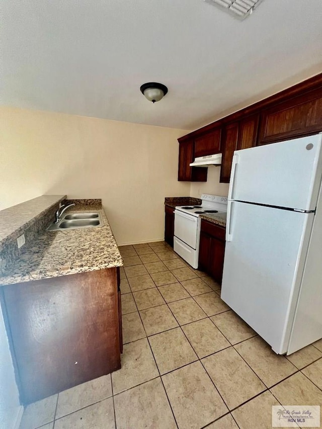 kitchen featuring light stone countertops, white appliances, light tile patterned flooring, and sink